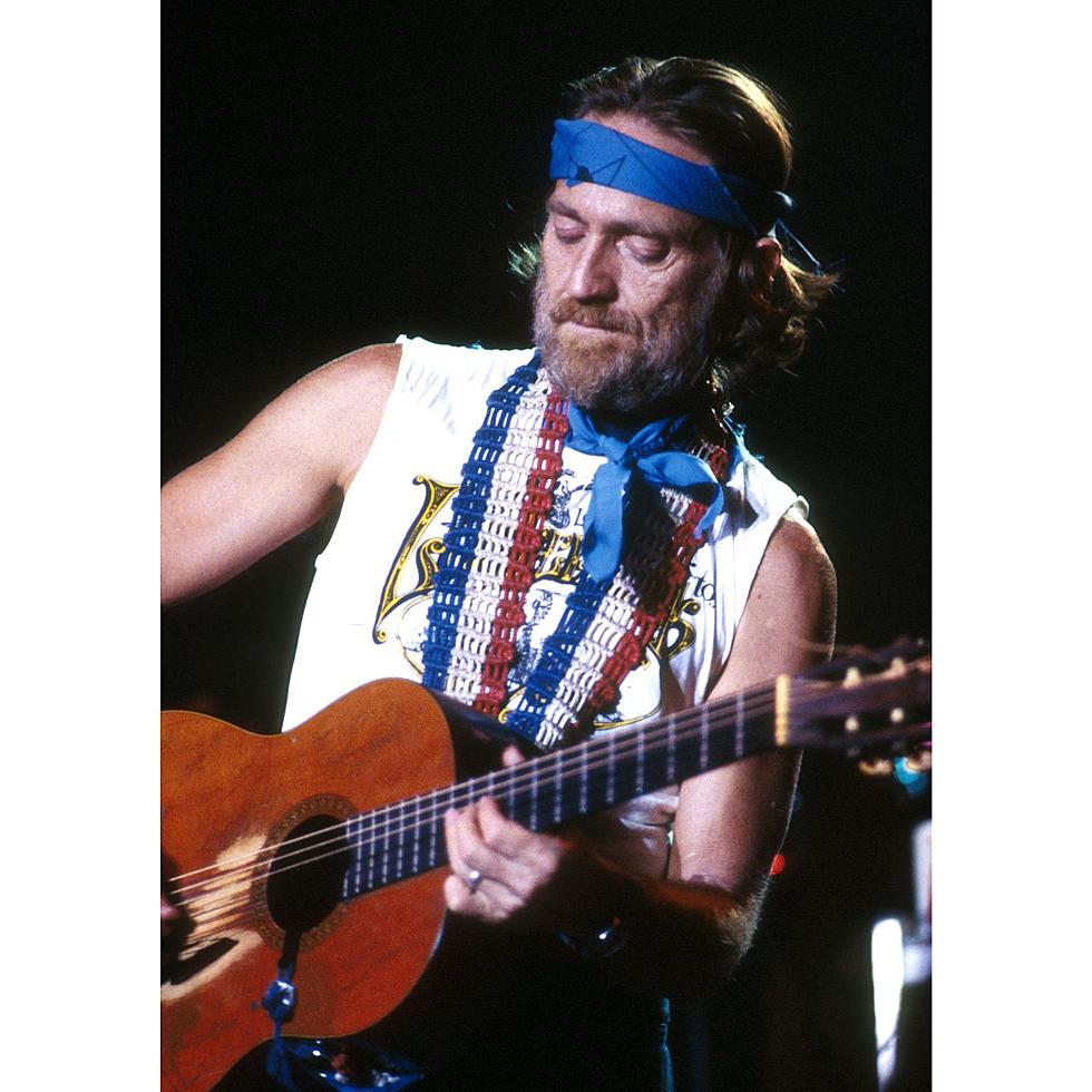 Willie Nelson playing an acoustic guitar in 1977